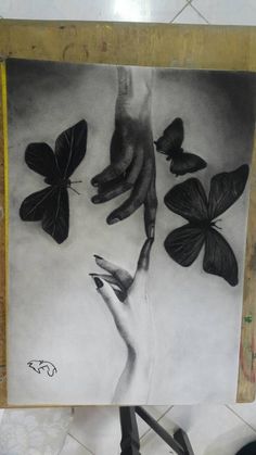 a black and white photo of a person's hand reaching for butterflies