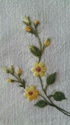 some yellow flowers are on the side of a piece of white fabric with green leaves