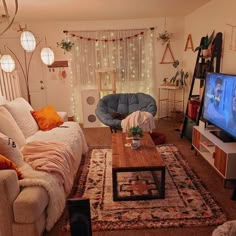 a living room filled with furniture and a flat screen tv sitting on top of a wooden table