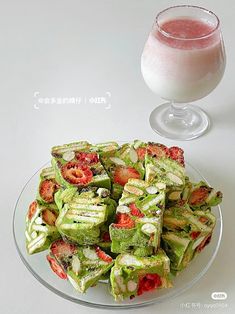 a plate full of cut up vegetables next to a glass of pink liquid on a table