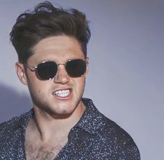 a man with sunglasses on his face wearing a black shirt and silver speckles