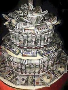 a cake made out of dollar bills sitting on top of a table