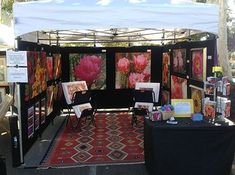 an outdoor booth with paintings and pictures on it