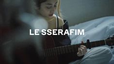 a woman sitting in bed playing a guitar with the words le serafim above her