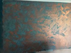 an abstract painting on the wall with green and gold paint, in a room that is being remodeled