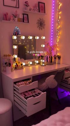 a white desk topped with drawers under a mirror and lights on the wall behind it