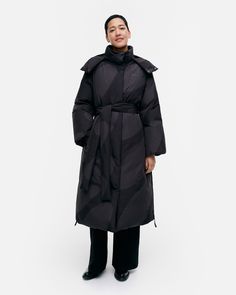 The Suoja down coat is made of recycled polyester with a certified down filling and it has a slim, straight fit. The long coat features the Linssi pattern, and it has a high collar and a detachable hood that can be tightened with drawstrings. There is a zipper and a snap button closure in the front and the Marimekko logo printed onto the left chest. The front welt pockets have snap button closures, and the sleeve ends have ribbed cuffs. The coat comes with a separate belt, and it has belt loops in the back. The side seams have long slits at the hem with concealed zipper closures.

The oval Linssi (lens) print is one of the gems in Marimekko’s pattern archive – timeless and fashionable year after year. Kaarina Kellomäki designed Linssi in 1966. Detachable Hood, Down Coat, High Collar, Long Coat, Black Coat, Welt Pockets, Cloth Bags, Snap Button, Woven Fabric