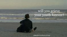 a man sitting on top of a sandy beach next to the ocean with a quote above it