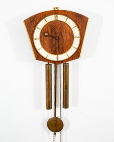 a wooden clock hanging from the side of a wall with chains attached to it's sides