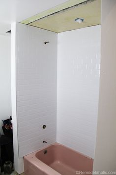 a pink bath tub sitting inside of a bathroom next to a white wall and ceiling