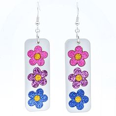 Fun, subtle, and lightweight - bisexual flag color flowers against a silvery background make sweet earrings. Three glitter acrylic daisies (pink, purple, blue) are featured against a shiny light-silver background. The backs are solid white. These earrings hang about 3-inches long overall, and they're about 3/4-inch wide. They weigh about 4 grams each (less than a dime), so they're easy to wear. They feature silver-plated ear hooks and findings.  A fun way to show a bit of bisexual pride!  NOTE: Bi Flag, Functional Jewelry, Bisexual Flag, Pride Jewellery, Sweet Earrings, Silver Background, Glitter Acrylic, Pink Purple Blue, Glitter Acrylics