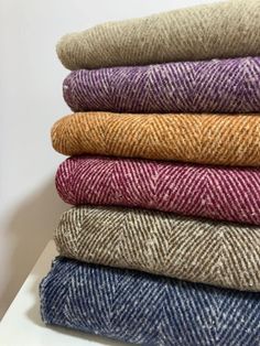 six different colored tweed fabrics stacked on top of each other