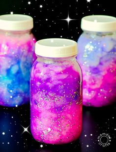 three jars filled with liquid and stars on top of a black table next to the words, how to create a nebula jar galaxy