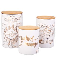 three ceramic canisters with wooden lids and labels on the sides, one has a hogwart map