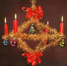 an ornament shaped like a christmas tree with lit candles and bells on it