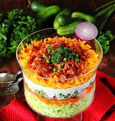 a layered salad in a glass dish with broccoli and other vegetables