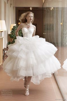 a woman in a white dress walking down a hallway