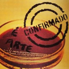 a glass filled with liquid sitting on top of a table next to a sign that says confermaio arte