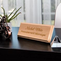 a wooden business card holder sitting on top of a desk next to an office chair