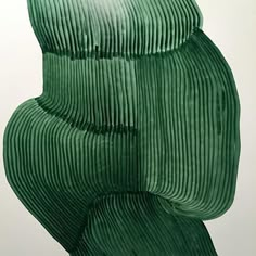 a large green sculpture sitting on top of a white wall