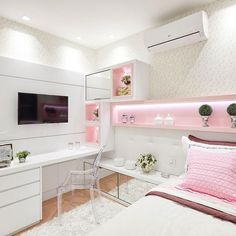 a bedroom with white walls and pink lighting on the headboard, bed, desk and television