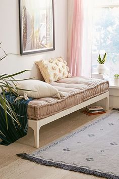 a white daybed sitting next to a window in a living room