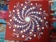 a red, white and blue painting with circles on the bottom is surrounded by magazines