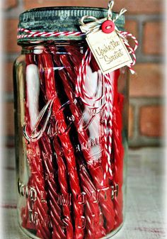 a jar filled with red candles sitting on top of a table