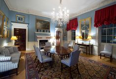 a formal dining room with blue walls and red curtains