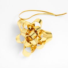 a gold bow ornament on a white background