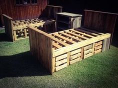 an outdoor bed made out of wooden pallets in the grass next to a building