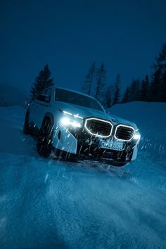 a car driving through the snow at night