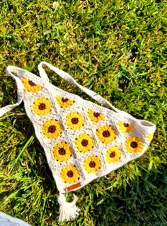 a crocheted sunflower bag laying on the grass