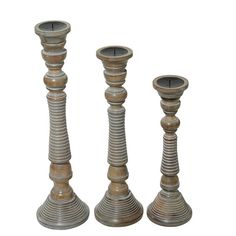 three metal candlesticks sitting next to each other