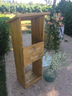 a wooden podium sitting on top of a gravel ground next to a potted plant