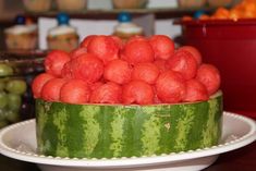 a watermelon cake with lots of fruit in the middle on a white plate