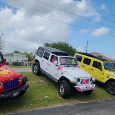 three jeeps parked next to each other on the grass