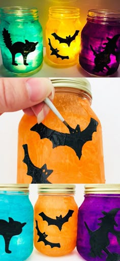 halloween mason jars with bats painted on them and one is holding a paintbrush in it