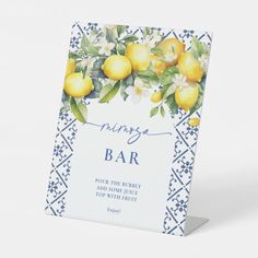 a blue and white card with lemons hanging from it's sides on a stand