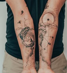 two people with tattoos on their arms are holding hands in the shape of planets and stars