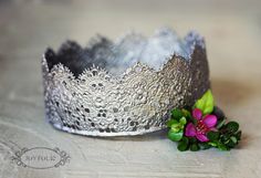 a silver crown with flowers on the side