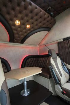 the interior of a vehicle with leather upholstered seats and tables in front of it