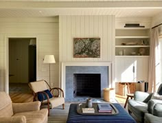 a living room filled with furniture and a fire place under a painting on the wall