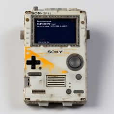 an old video game console sitting on top of a white table next to a wall