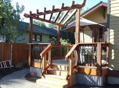 an outdoor patio with wooden steps and pergolated trellis on the side of it