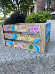 a wooden crate painted with flowers and the word fronkie on it's side