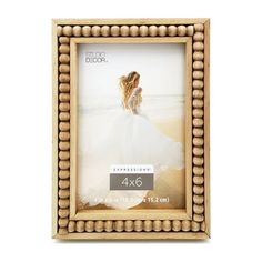 a wooden frame with beading around the edges and a woman in a white dress