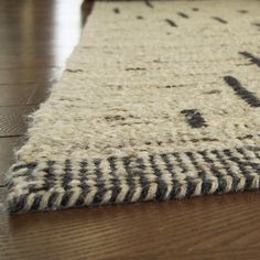 a close up of a rug on the floor with a wooden floor in the background