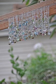 a bunch of glass beads hanging from a wooden beam