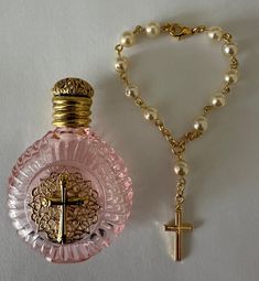 This Holy Water Bottle and Decade Rosary beads bracelet are hand made by Bohemian craftsman . The pink glass bottle is fitted with brass Holy Cross ornament and screw on brass lid with rubber seal. Decade Rosary beads are made from pearls look like glass . The bracelet is fitted with clasp lock and brass Holy Cross .Item is packaged in a good quality gift box. Catholic Rosary Aesthetic, What To Do With Beads, Cheap Pink Rosary As Gift, Pink Rosary Aesthetic, Handmade Pink Rosary Bracelet, Rosary Party Favors, Rosary Aesthetic, Relics And Artifacts, Home Made Gifts